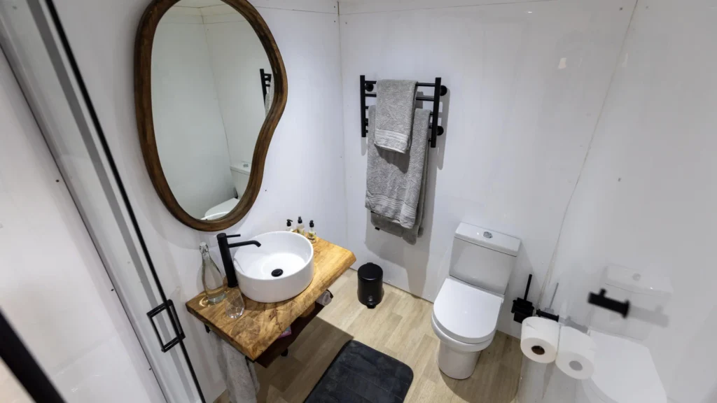 Modern en-suite bathroom on an Okavango Delta houseboat featuring a stylish wooden vanity, vessel sink, and clean, minimalist design.