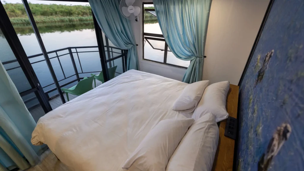 Bright and airy bedroom aboard a houseboat in the Okavango Delta, Botswana â€“ tranquil riverfront views and elegant comfort on the water.