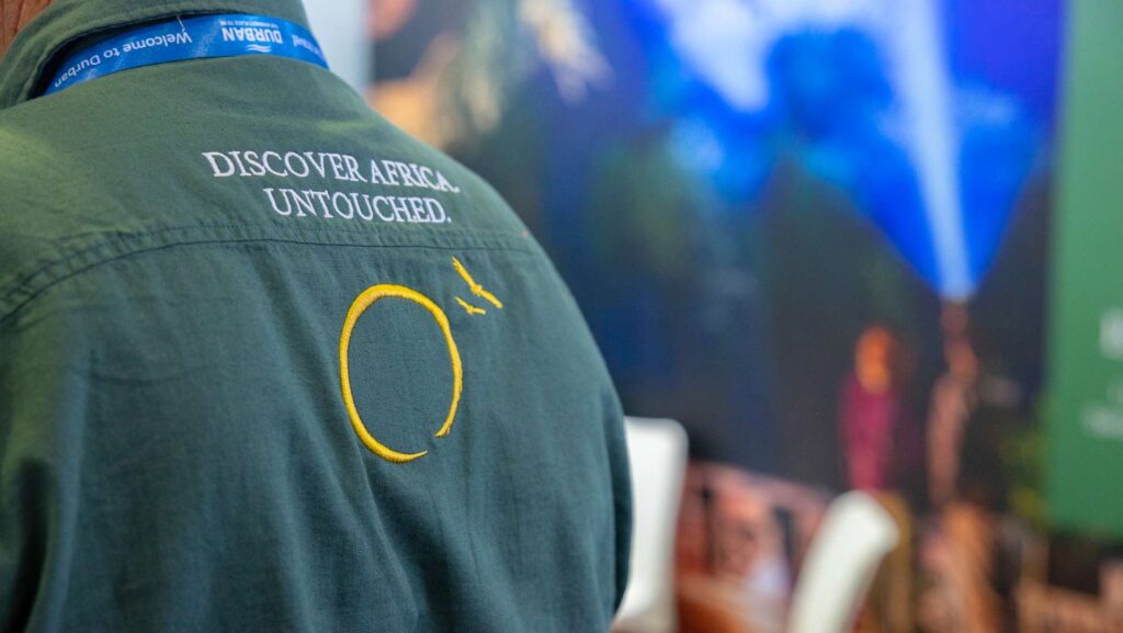 Logo of Untouched Safaris with Slogan on the back of a shirt.